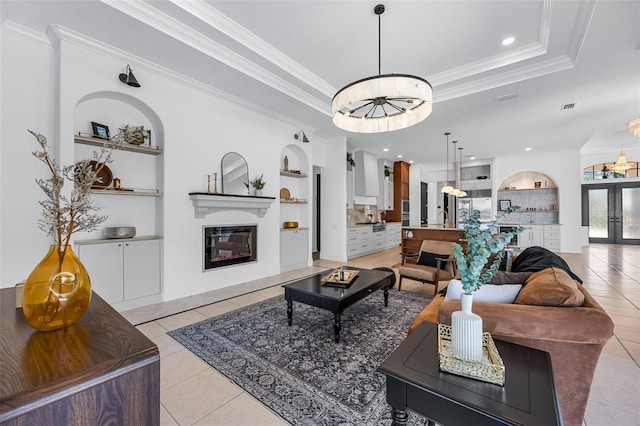 2873 Bellwind Cir, Rockledge, FL 32955 - living room featuring light tile patterned floors, a glass covered fireplace, ornamental molding, built in features, and a raised ceiling