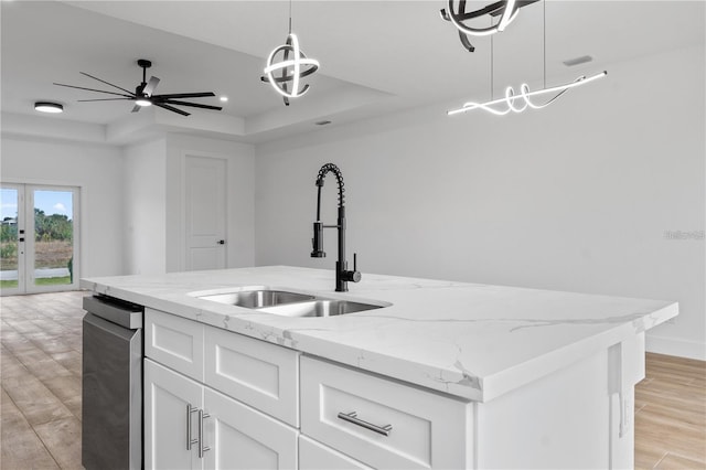 10071 Kingsville Dr, Port Charlotte, FL 33981 - kitchen with a raised ceiling, a center island with sink, white cabinets, and pendant lighting