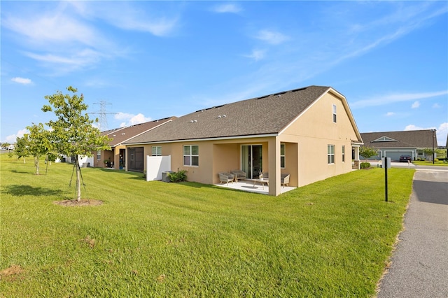 3279 Canna Lily Pl, Clermont, FL 34711 - back of property with stucco siding, roof with shingles, a yard, and a patio area