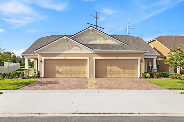 3279 Canna Lily Pl, Clermont, FL 34711 - craftsman inspired home with decorative driveway, an attached garage, stucco siding, and roof with shingles