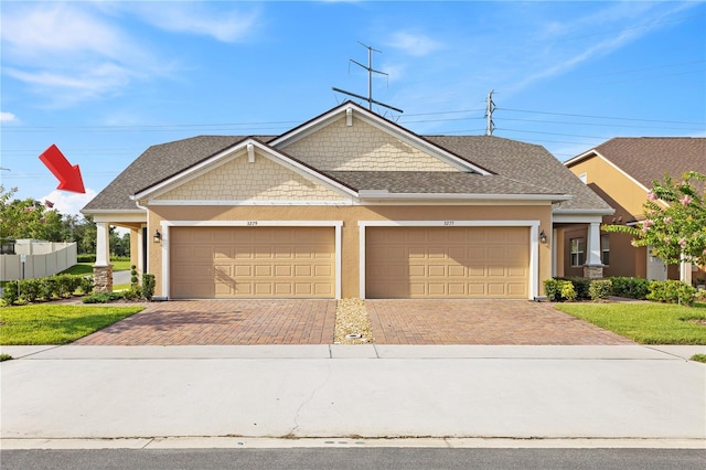 3279 Canna Lily Pl, Clermont, FL 34711 - craftsman-style home with decorative driveway, a garage, roof with shingles, and stucco siding