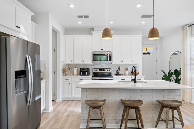3279 Canna Lily Pl, Clermont, FL 34711 - kitchen with appliances with stainless steel finishes, backsplash, light countertops, a breakfast bar area, and recessed lighting
