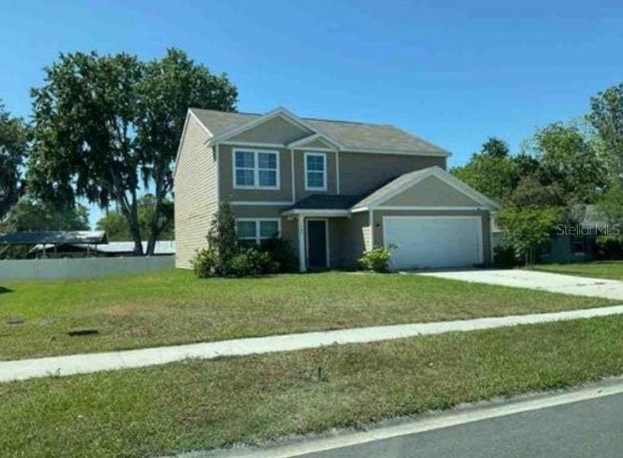 768 Constitution Pl, Macclenny, FL 32063 - view of front of home with an attached garage, driveway, and a front yard