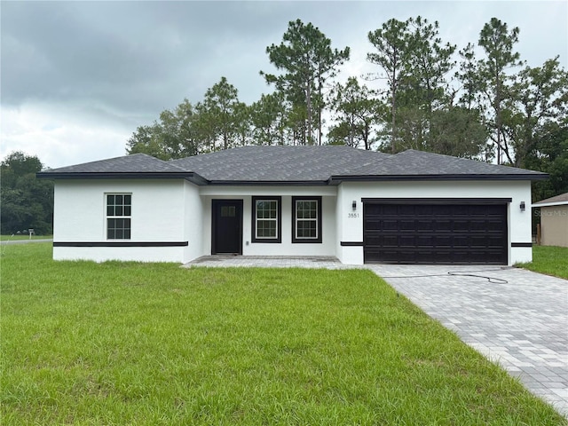3551 W Fleece Dr, Dunnellon, FL 34433 - view of front of property with decorative driveway, an attached garage, a front yard, and stucco siding