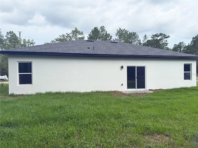 3551 W Fleece Dr, Dunnellon, FL 34433 - back of property with stucco siding, a lawn, and a shingled roof