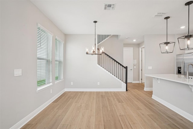 16526 Silver Brook Way, Winter Garden, FL 34787 - unfurnished living room with a chandelier, light wood finished floors, stairs, and recessed lighting