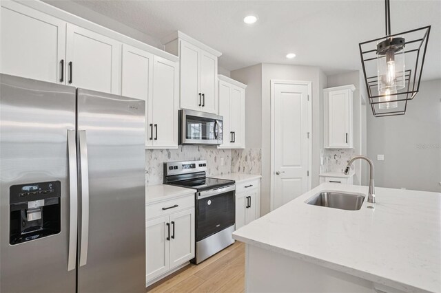 16526 Silver Brook Way, Winter Garden, FL 34787 - kitchen with appliances with stainless steel finishes, light wood-style floors, decorative backsplash, white cabinetry, and recessed lighting