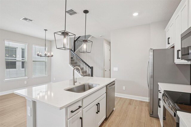16526 Silver Brook Way, Winter Garden, FL 34787 - kitchen with stainless steel appliances, light wood-style floors, a chandelier, light countertops, and pendant lighting