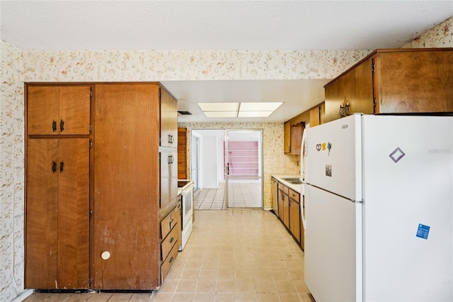 2020 Cocos Ct, Winter Park, FL 32792 - kitchen with freestanding refrigerator, wallpapered walls, brown cabinetry, light countertops, and light tile patterned floors