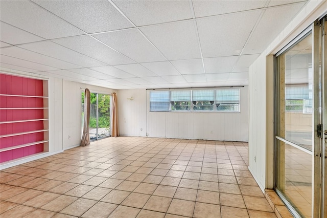 2020 Cocos Ct, Winter Park, FL 32792 - empty room featuring built in shelves, a drop ceiling, light tile patterned floors, and wood walls