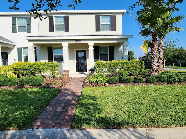 11802 Pulitzer Pl, Orlando, FL 32832 - view of front of property with stucco siding, a front lawn, and a porch