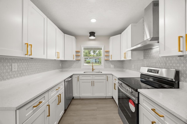 4714 Abaca St, Orlando, FL 32808 - kitchen with wall chimney exhaust hood, appliances with stainless steel finishes, open shelves, white cabinets, and light wood-type flooring
