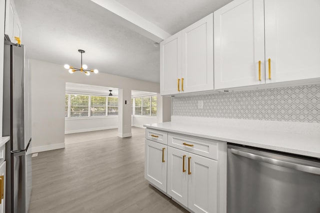 4714 Abaca St, Orlando, FL 32808 - kitchen with appliances with stainless steel finishes, a chandelier, decorative backsplash, light countertops, and white cabinets