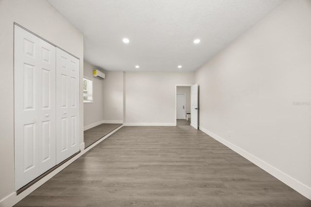 4714 Abaca St, Orlando, FL 32808 - unfurnished bedroom featuring an AC wall unit, recessed lighting, wood finished floors, and a closet