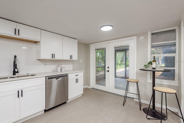 709 1st Ave NE, Largo, FL 33770 - kitchen featuring dishwasher, french doors, light wood-style floors, light countertops, and white cabinets