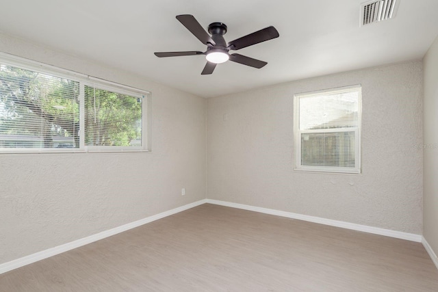 709 1st Ave NE, Largo, FL 33770 - empty room featuring wood finished floors, a ceiling fan, and a textured wall