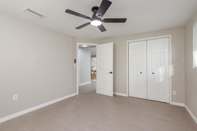 709 1st Ave NE, Largo, FL 33770 - unfurnished bedroom with light wood-style flooring, a closet, and ceiling fan