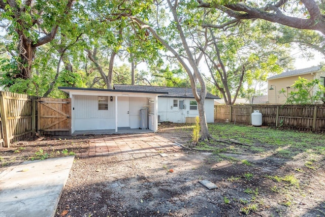 709 1st Ave NE, Largo, FL 33770 - rear view of house featuring a fenced backyard and a gate