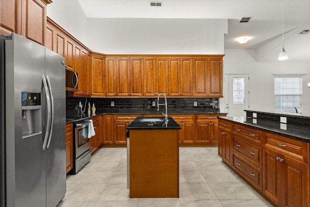18920 Overton St, Orlando, FL 32833 - kitchen with appliances with stainless steel finishes, a center island with sink, tasteful backsplash, and dark stone counters