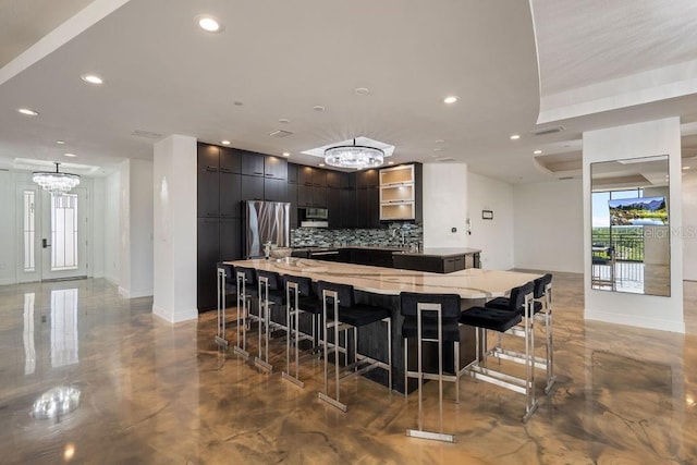 111 E Monument Ave Unit 801, Kissimmee, FL 34741 - kitchen featuring a chandelier, appliances with stainless steel finishes, backsplash, a spacious island, and light stone countertops