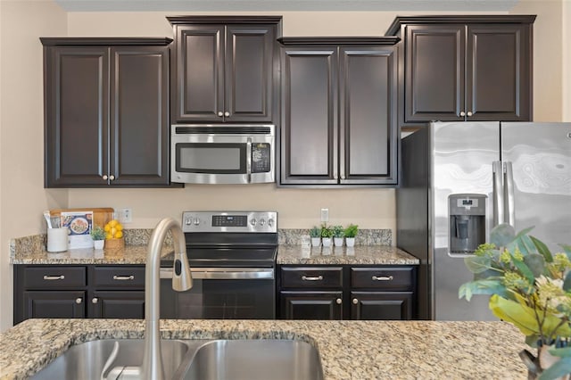 14897 Evergreen Oak Loop, Winter Garden, FL 34787 - kitchen featuring stainless steel appliances, light stone counters, and dark brown cabinetry