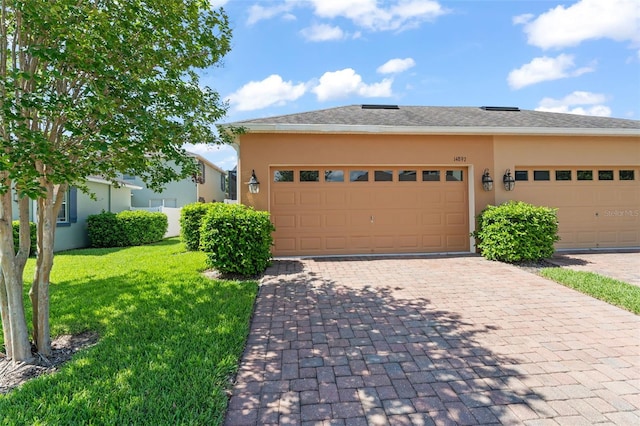 14897 Evergreen Oak Loop, Winter Garden, FL 34787 - view of front of home with stucco siding, a front lawn, decorative driveway, and an attached garage