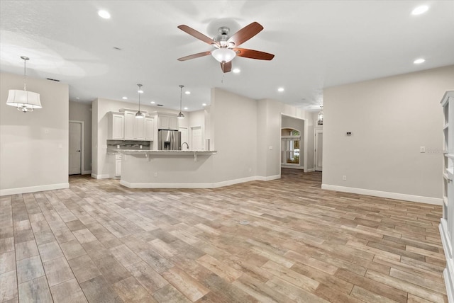 917 Southern Oak Ln, Apopka, FL 32712 - unfurnished living room featuring ceiling fan, light wood-style flooring, arched walkways, and recessed lighting