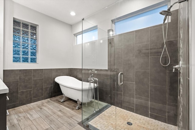 917 Southern Oak Ln, Apopka, FL 32712 - full bathroom with tile walls, a stall shower, a freestanding bath, wainscoting, and recessed lighting
