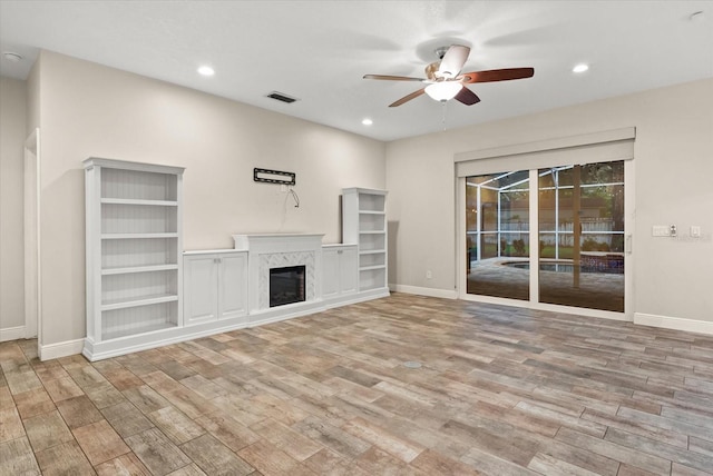 917 Southern Oak Ln, Apopka, FL 32712 - unfurnished living room featuring ceiling fan, wood finished floors, a high end fireplace, and recessed lighting
