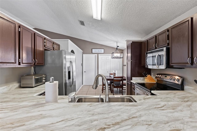 2737 Cahill Way, Lake Mary, FL 32746 - kitchen featuring stainless steel appliances, vaulted ceiling, a textured ceiling, pendant lighting, and dark brown cabinets