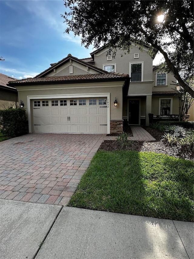 1452 Moon Valley Dr, Davenport, FL 33896 - traditional home featuring decorative driveway, an attached garage, stucco siding, and stone siding