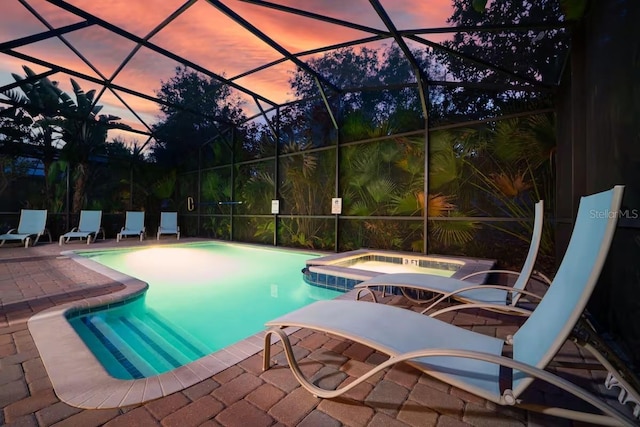1452 Moon Valley Dr, Davenport, FL 33896 - pool at dusk featuring a patio, a pool with connected hot tub, and glass enclosure