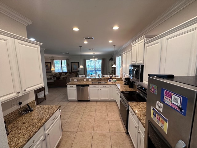 1452 Moon Valley Dr, Davenport, FL 33896 - kitchen featuring stainless steel appliances, ornamental molding, a peninsula, recessed lighting, and white cabinets