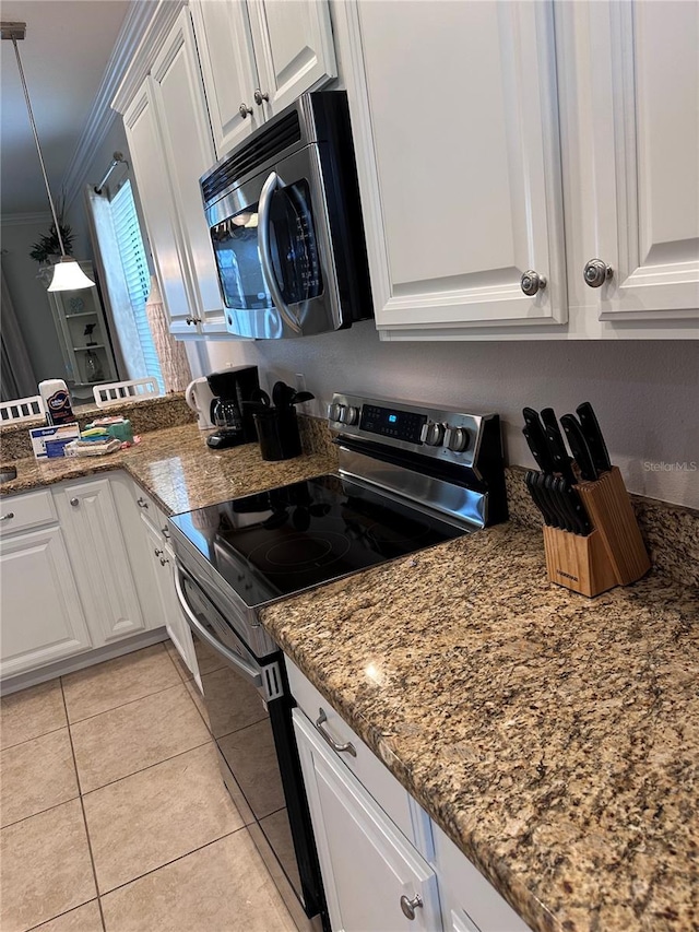 1452 Moon Valley Dr, Davenport, FL 33896 - kitchen with appliances with stainless steel finishes, crown molding, light tile patterned floors, white cabinetry, and decorative light fixtures