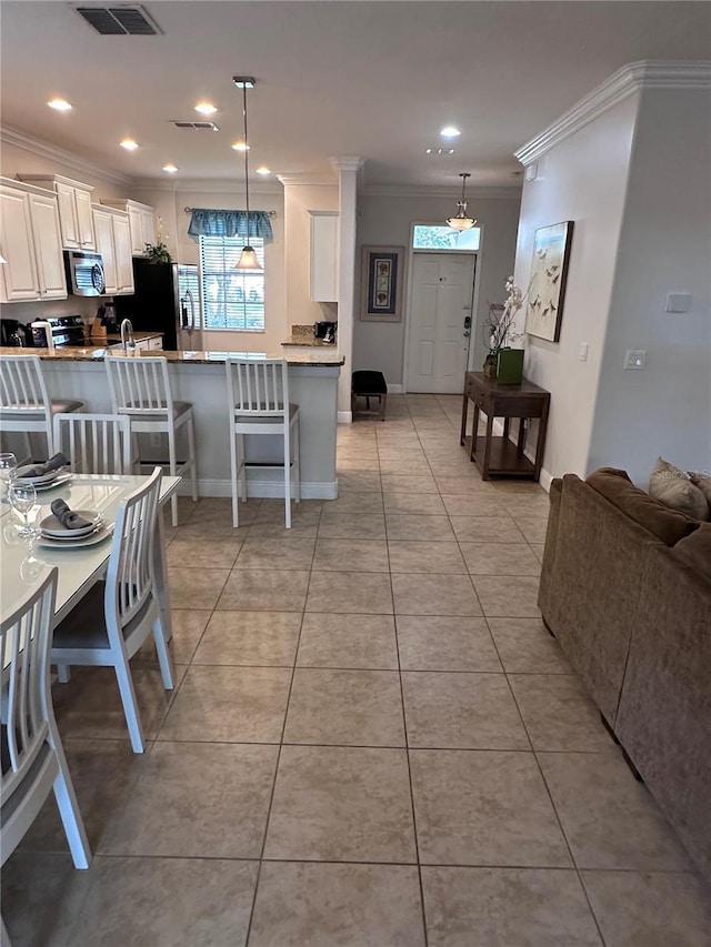 1452 Moon Valley Dr, Davenport, FL 33896 - dining space featuring crown molding, light tile patterned floors, and recessed lighting