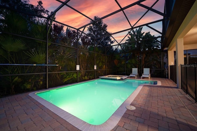 1452 Moon Valley Dr, Davenport, FL 33896 - pool at dusk featuring a patio, a pool with connected hot tub, and a lanai