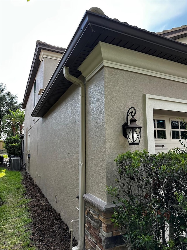 1452 Moon Valley Dr, Davenport, FL 33896 - view of side of property with stucco siding and a central air condition unit