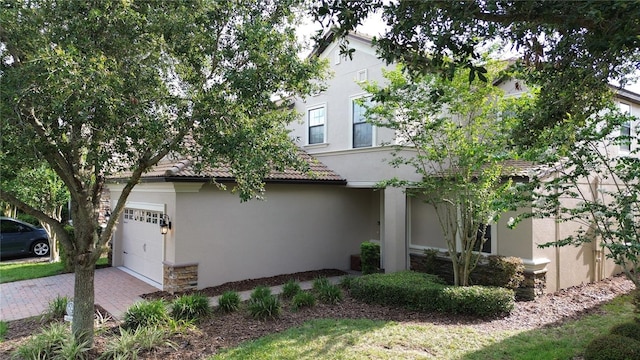 1452 Moon Valley Dr, Davenport, FL 33896 - view of front of property featuring stone siding, stucco siding, a garage, and a tile roof