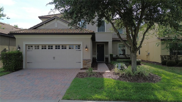 1452 Moon Valley Dr, Davenport, FL 33896 - view of front of house featuring a garage, decorative driveway, stone siding, and a tiled roof