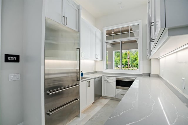 4007 Grande Brick Loop Unit 13, Orlando, FL 32837 - kitchen featuring appliances with stainless steel finishes, light stone countertops, and white cabinetry