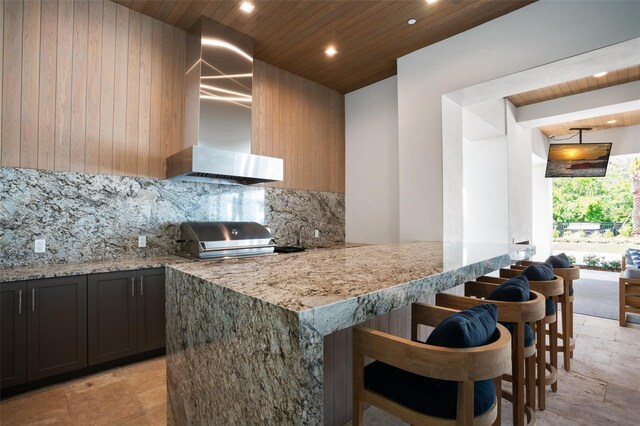 4007 Grande Brick Loop Unit 13, Orlando, FL 32837 - kitchen featuring wall chimney exhaust hood, wooden ceiling, tasteful backsplash, recessed lighting, and light stone countertops