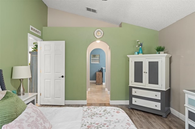 2042 Hayfield Way, Apopka, FL 32712 - bedroom with vaulted ceiling, arched walkways, wood finished floors, and a textured ceiling