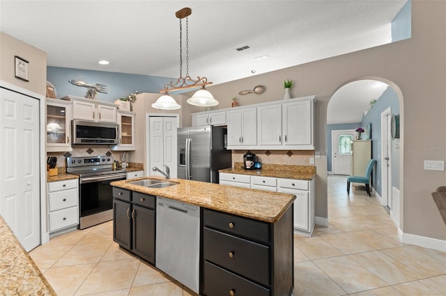 2042 Hayfield Way, Apopka, FL 32712 - kitchen with appliances with stainless steel finishes, white cabinets, light tile patterned floors, decorative backsplash, and arched walkways
