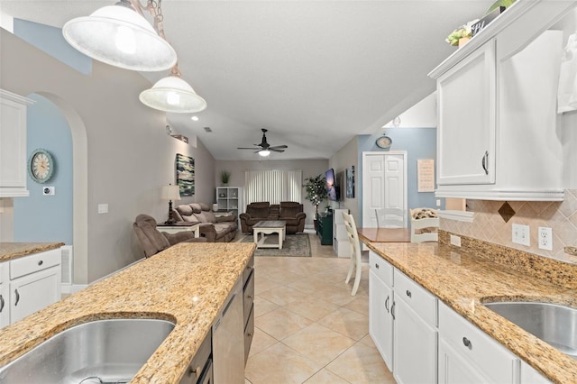 2042 Hayfield Way, Apopka, FL 32712 - kitchen featuring ceiling fan, lofted ceiling, arched walkways, decorative backsplash, and white cabinetry