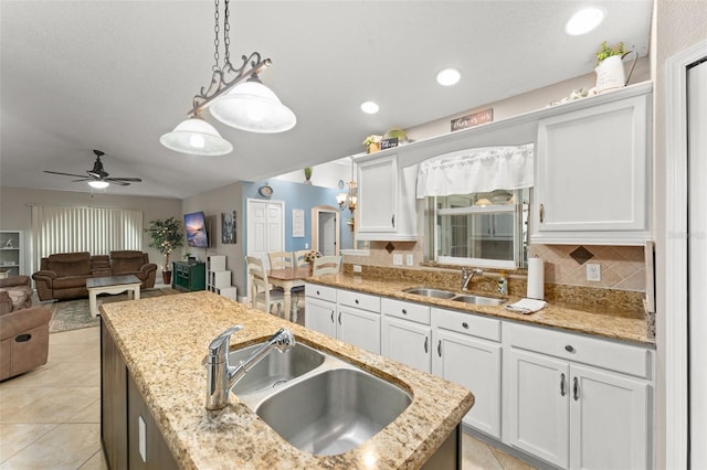 2042 Hayfield Way, Apopka, FL 32712 - kitchen with white cabinets, hanging light fixtures, ceiling fan, decorative backsplash, and light tile patterned flooring