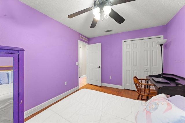 2042 Hayfield Way, Apopka, FL 32712 - bedroom with wood finished floors, a closet, a ceiling fan, and a textured ceiling