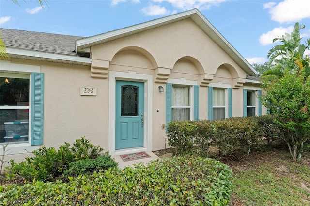 2042 Hayfield Way, Apopka, FL 32712 - view of exterior entry featuring stucco siding and a shingled roof