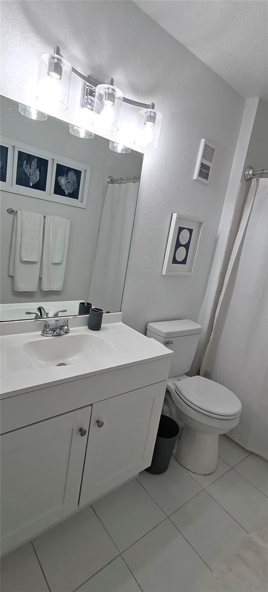 7220 Westpointe Blvd Unit 1429, Orlando, FL 32835 - bathroom with tile patterned floors, vanity, a shower with curtain, and a textured ceiling