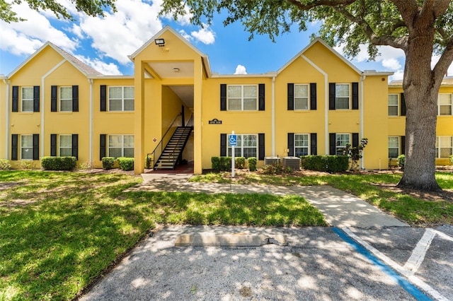 2041 Dixie Belle Dr Unit 2041C, Orlando, FL 32812 - view of front of home featuring stucco siding, stairs, and a front lawn
