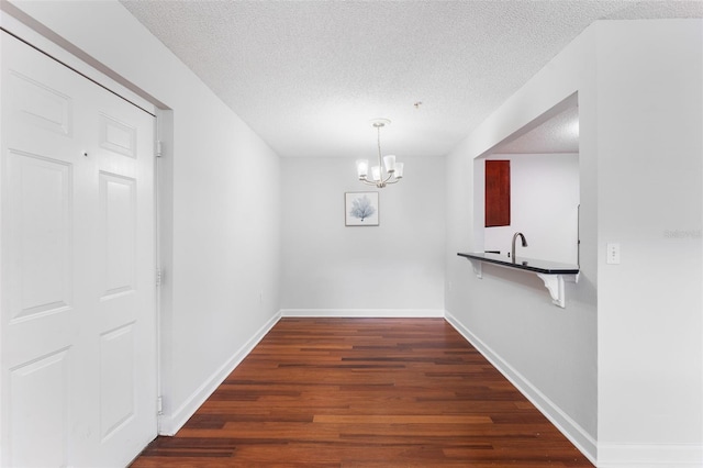 2041 Dixie Belle Dr Unit 2041C, Orlando, FL 32812 - unfurnished dining area featuring a textured ceiling, dark wood-style floors, and a chandelier
